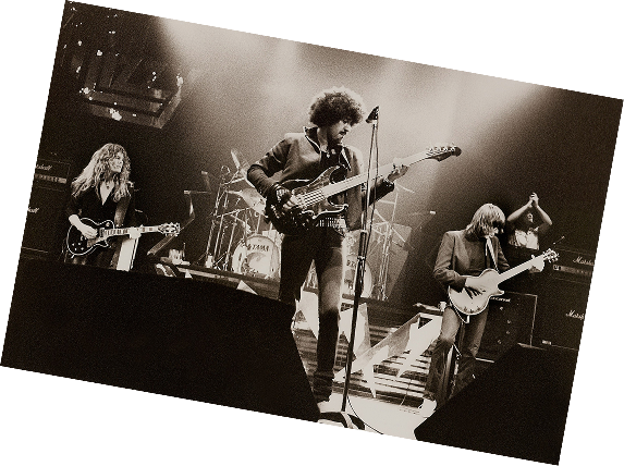 Thin Lizzy on stage with guitars, in a black-and-white photo from 1983