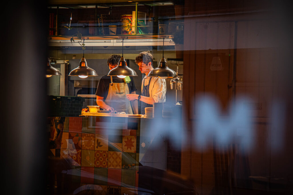Chefs at work in The Granary's kitchen, seen through a window
