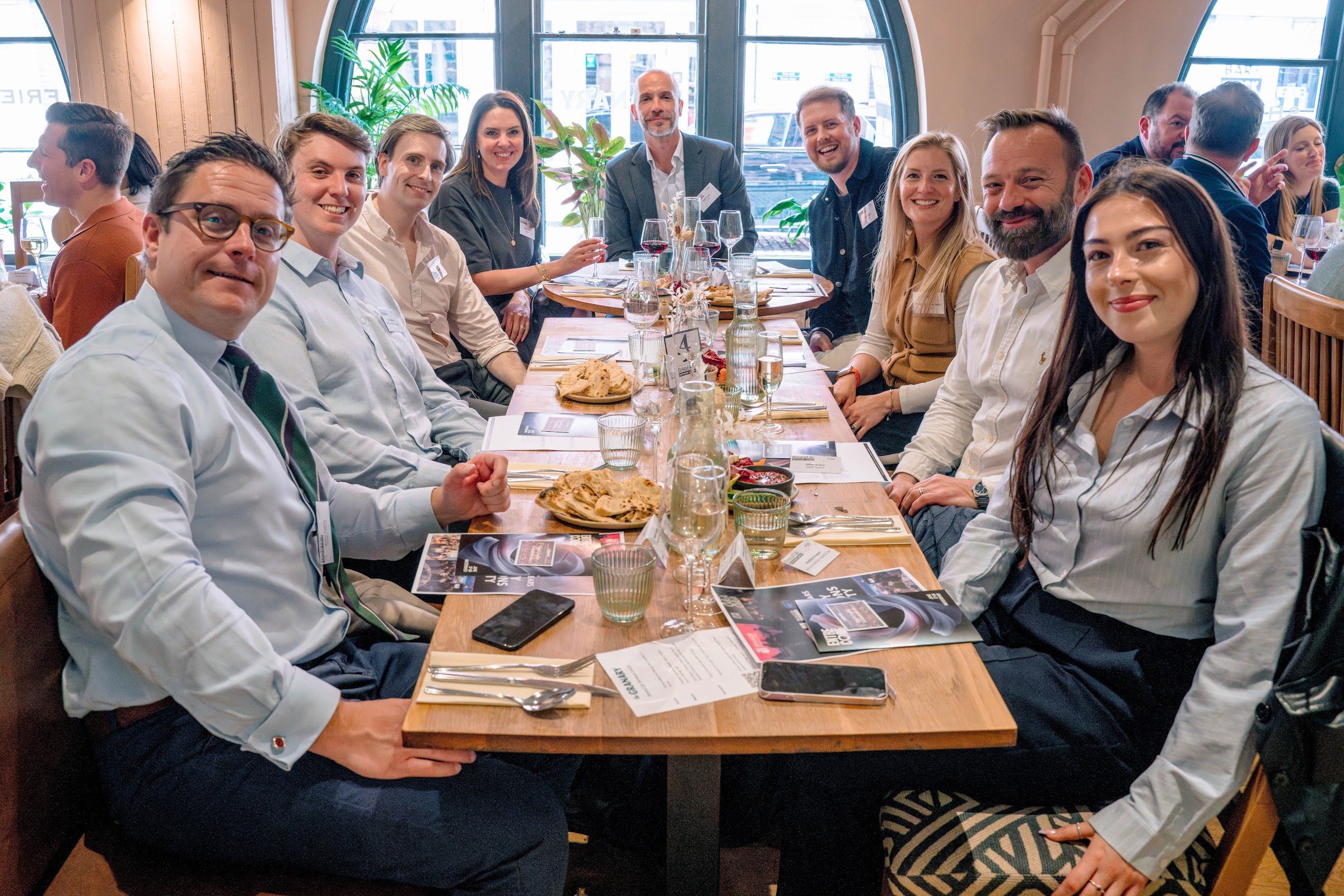 Guests at a long-table business lunch in The Granary restaurant, beneath the arched windows