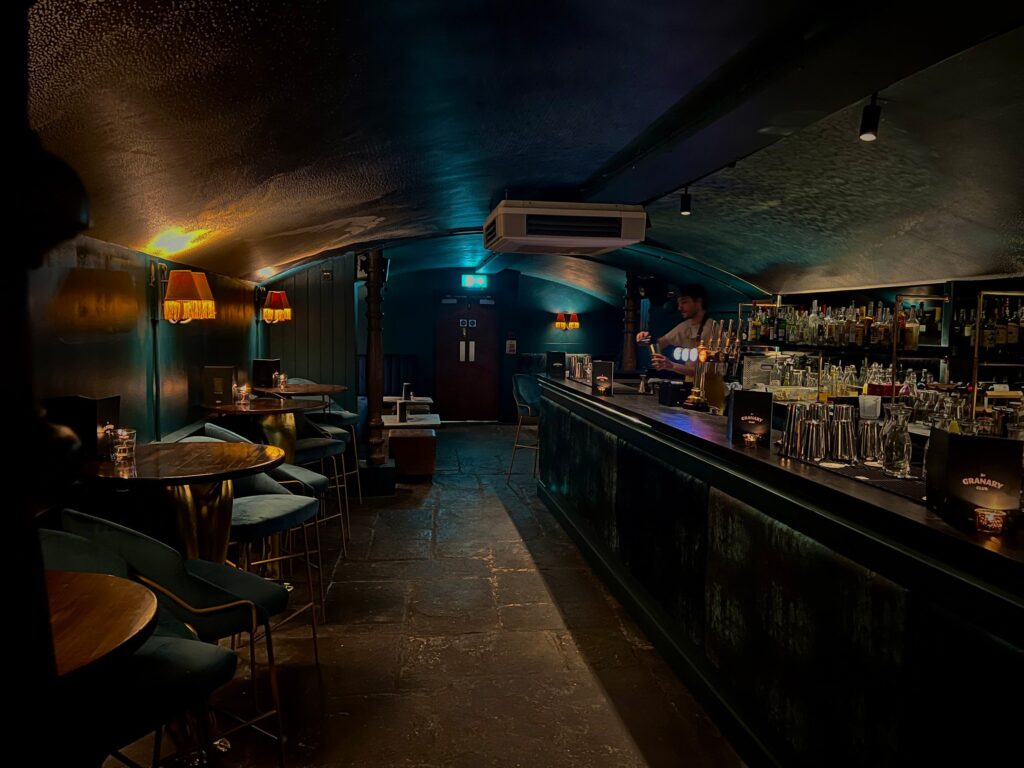 The underground bar of The Granary Club, with a vaulted ceiling and a stone-flagged floor