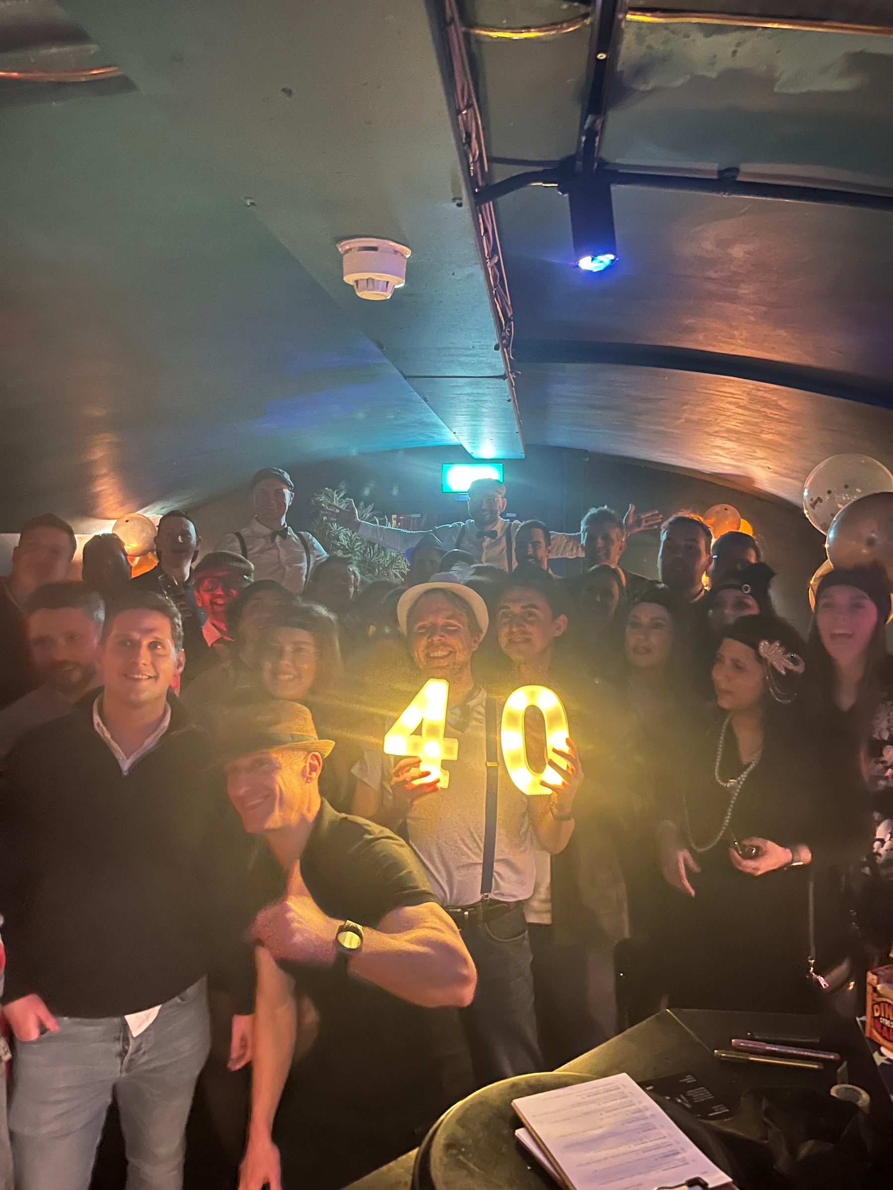 Guests celebrating a 40th birthday in The Granary Club, holding light-up number 40 signs