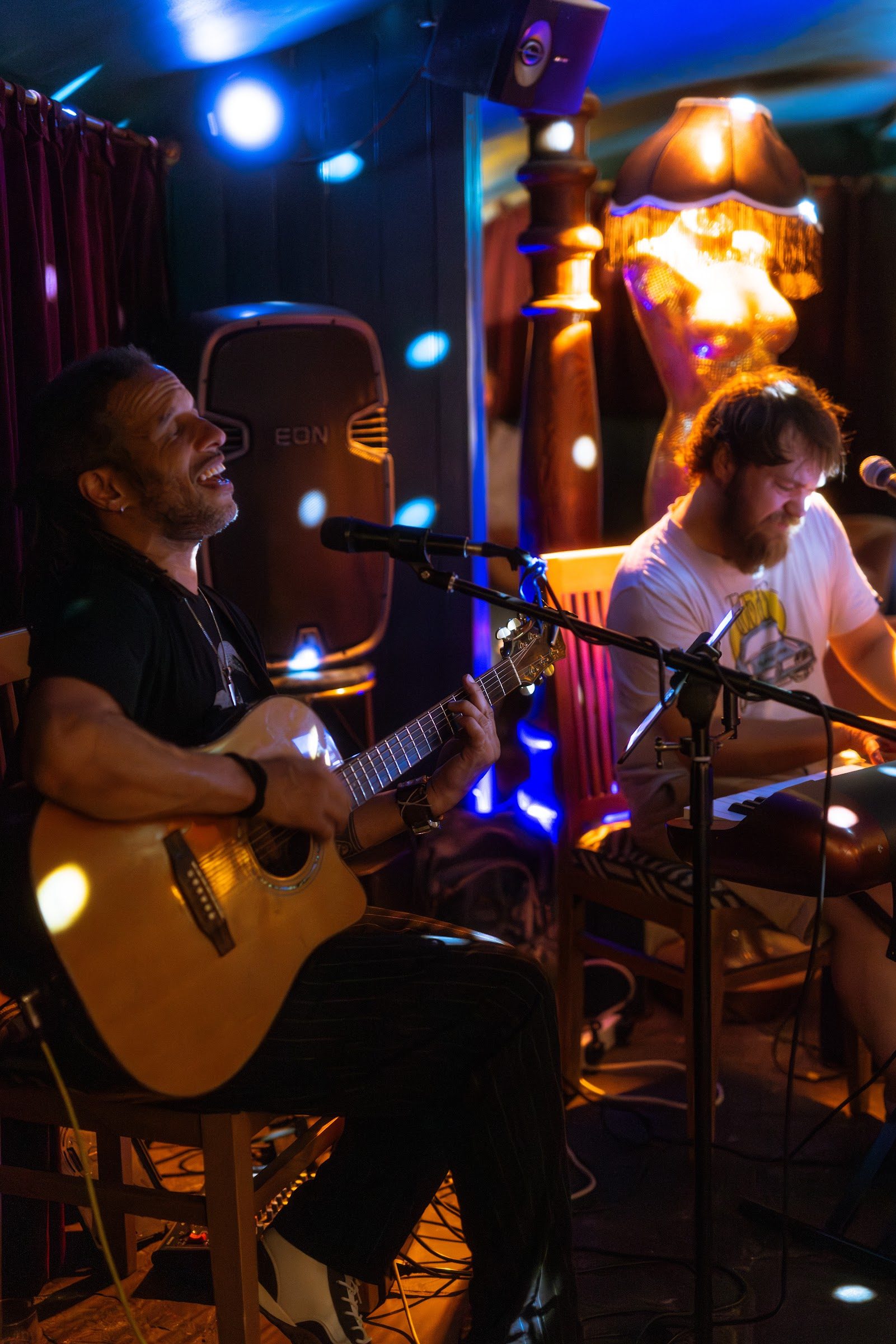 A singer with an acoustic guitar and a keyboard player performing live in The Granary Club